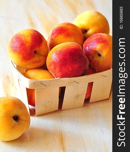 Yellow-red peaches lie in a small basket. Yellow-red peaches lie in a small basket