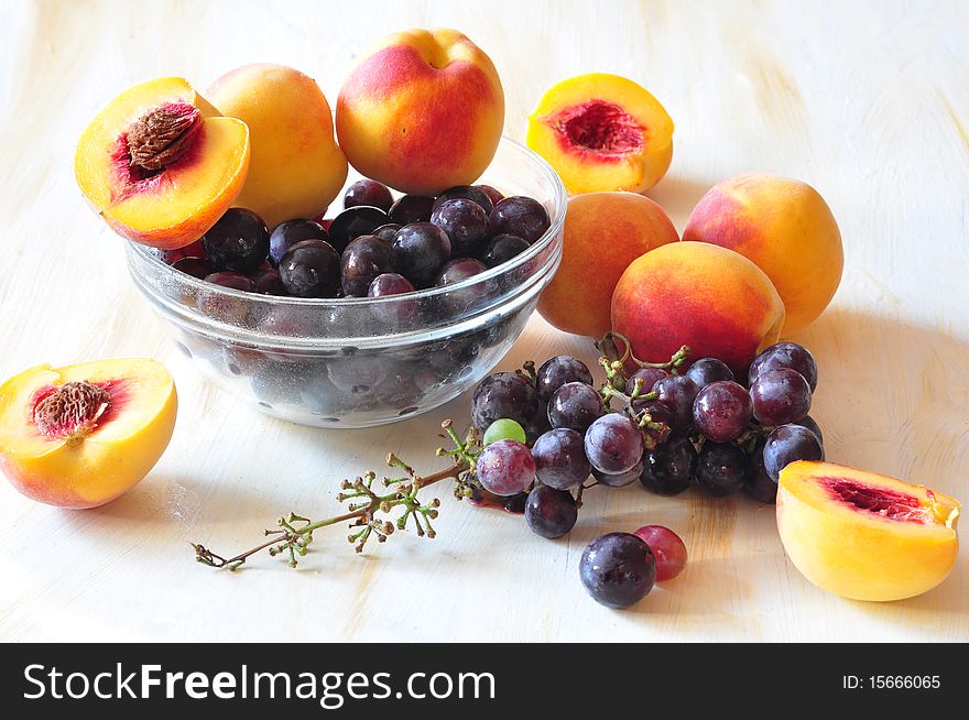 A vine and peaches lie in a dish