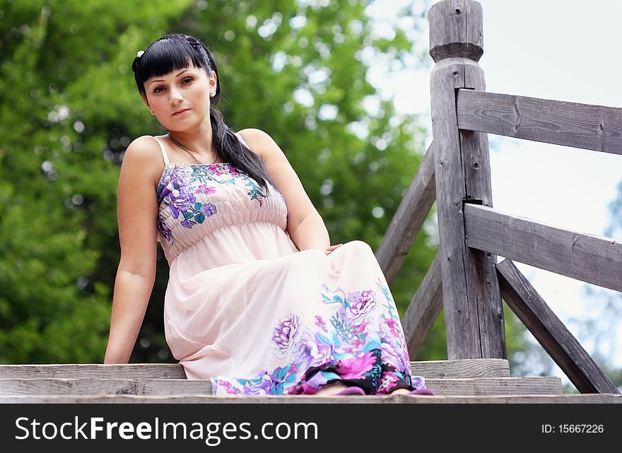 A beautiful girl sitting on wooden stairs