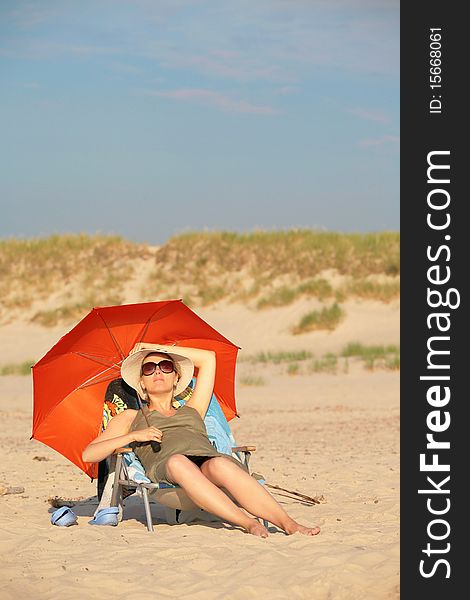 Young, pregnant woman, lying on the beach, relaxing and enjoying the sun. Young, pregnant woman, lying on the beach, relaxing and enjoying the sun.