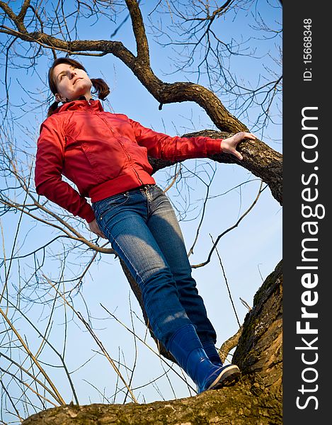 Girl standing on a dry tree, and looks forward