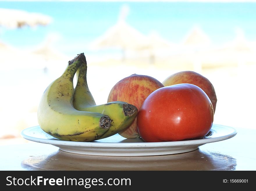 Ripe fruits dish plenty of vitamins, bananas, tomato and peaches in a luxury resort besides the sea. Ripe fruits dish plenty of vitamins, bananas, tomato and peaches in a luxury resort besides the sea