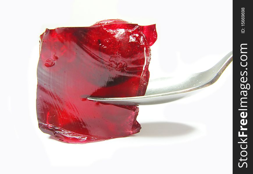 Red colored jelly marmalade with cherry and spoon inside