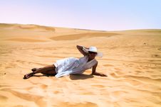Girl In White Dress Laying On The Desert Stock Photo