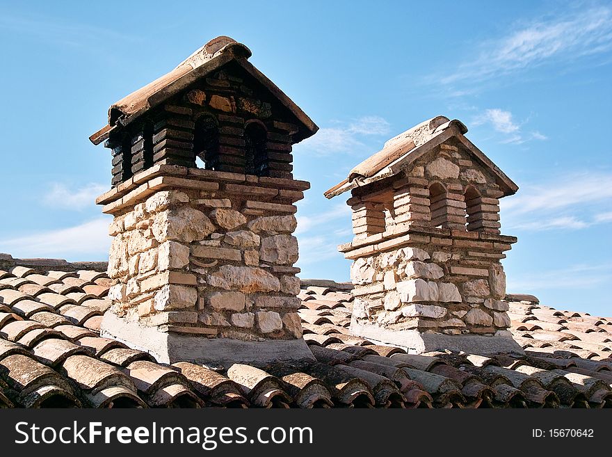 Two chimneys of stone and bricks in an italian house