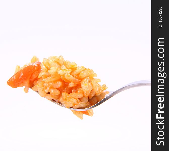 Risotto with tomatoes on a fork on white background