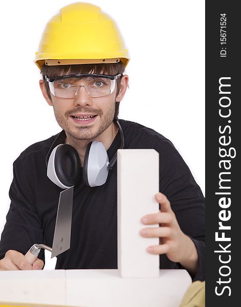 Happy construction worker with white brick and spade - isolated. Happy construction worker with white brick and spade - isolated