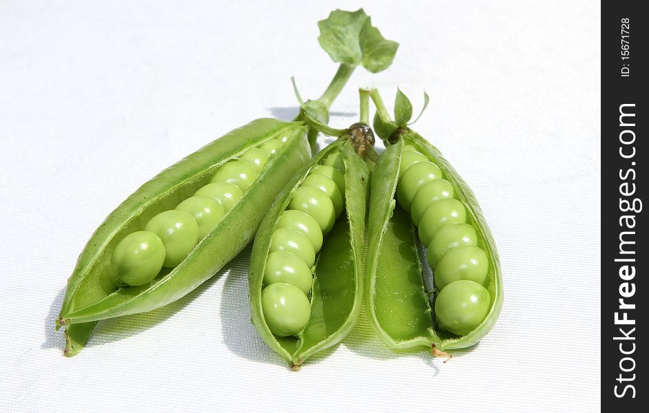 Pea pods open revealling fresh young green garden peas. Pea pods open revealling fresh young green garden peas.