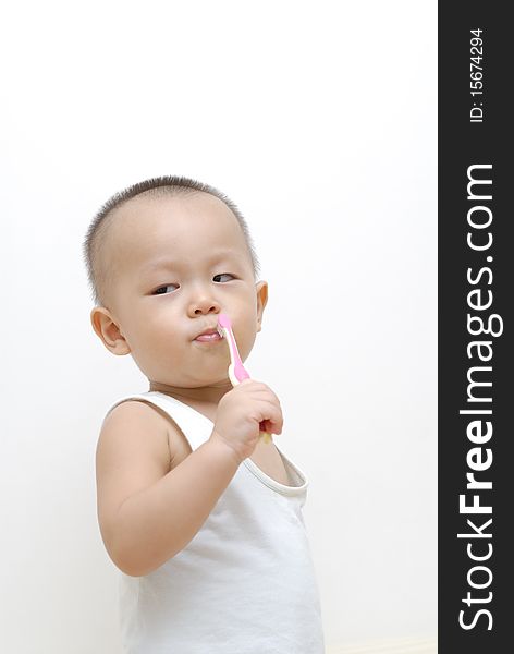It is a cute chinese baby, he is brushing his teeth. isolated. It is a cute chinese baby, he is brushing his teeth. isolated