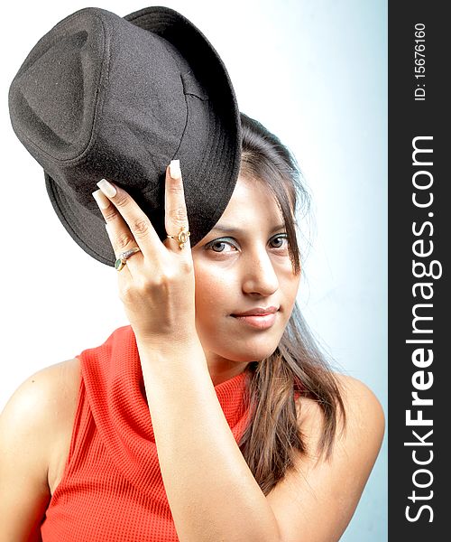 Bold girl with black hat in studio.