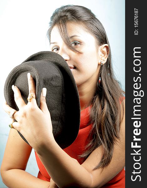 Bold girl with black hat in studio.