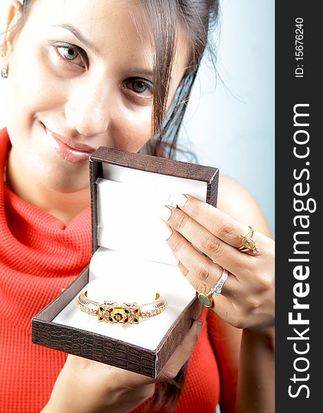 Girl holding golden bracelet jewellery with isolated background. Girl holding golden bracelet jewellery with isolated background.