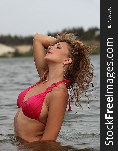 Attractive woman in the swimsuit on the river