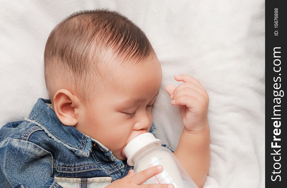 Asian boy sleeping and hold his milk bottle. Asian boy sleeping and hold his milk bottle