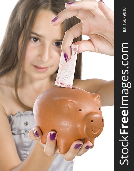 Girl saving money in a piggy bank isolated
