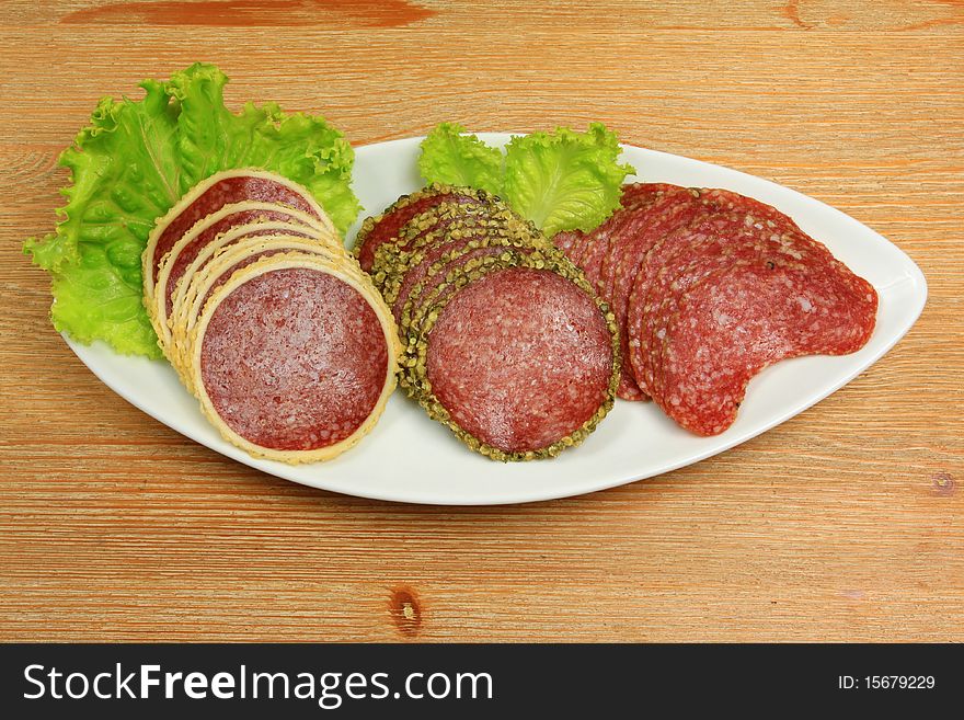 Three different kinds of salami meat on banquet plate with lettuce. Three different kinds of salami meat on banquet plate with lettuce