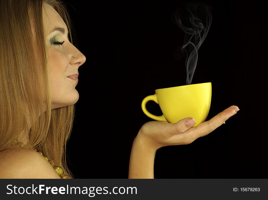 Portrait of a beautiful sexual girl with a cup of hot drink in hand, isolation on a black background. Portrait of a beautiful sexual girl with a cup of hot drink in hand, isolation on a black background