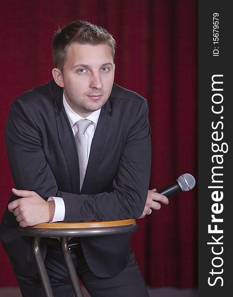 Portrait of male actor with microphone on the stage