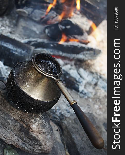 Image of hot coffee in coffeepot by the fire