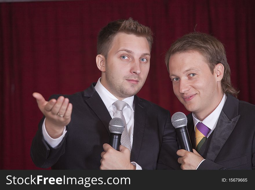 Two comedians with microphones on the stage. Two comedians with microphones on the stage
