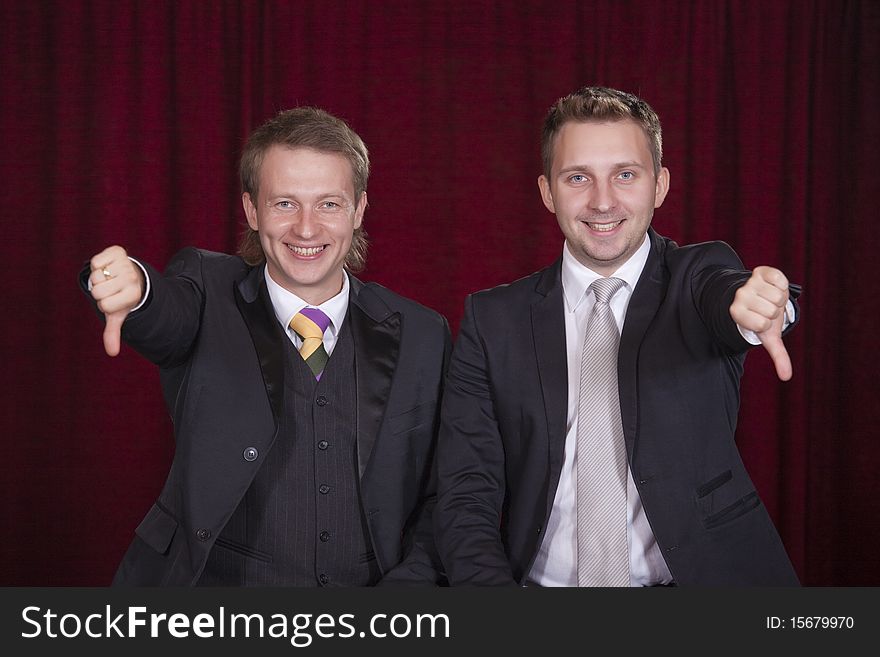 Two comedians holding thumbs down on the stage