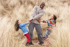 Father And Daughters Having Fun In Sand Dunes Stock Image