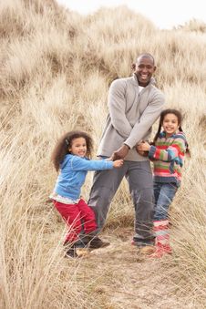 Father And Daughters Having Fun In Sand Dunes Stock Photo