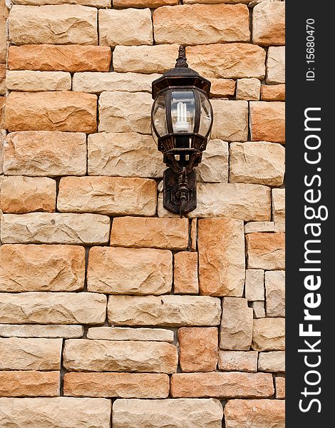 Lantern on rough brick wall