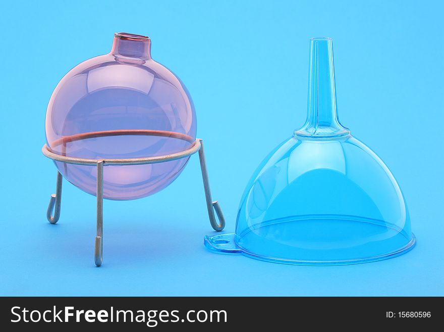 Flask and funnel on a blue background in laboratory