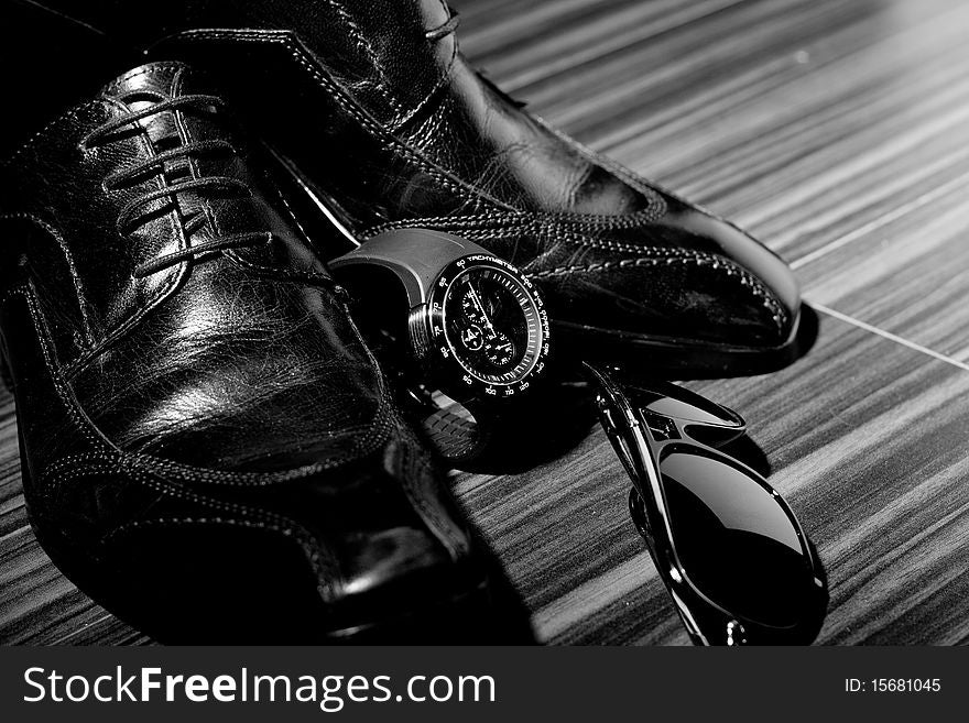 Dress shoes and a watch in the spotlight (focus on watch)