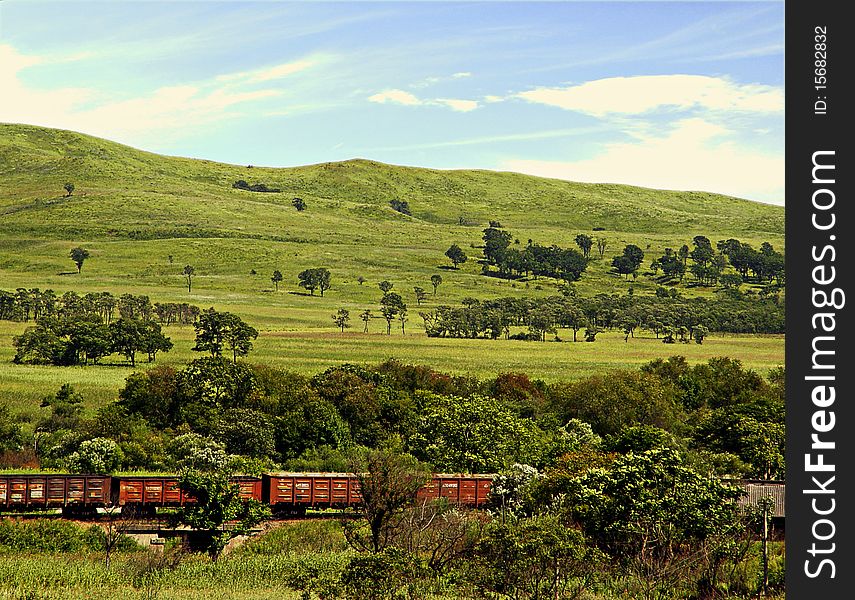 Red train going on a valley. Red train going on a valley