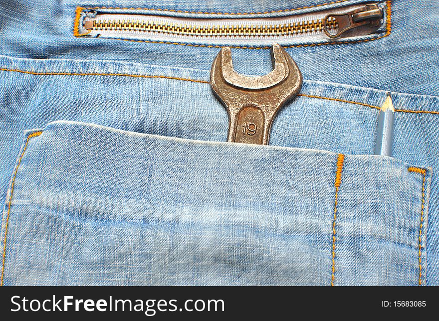 Old adjustable spanner in a blue jeans pocket. Old adjustable spanner in a blue jeans pocket