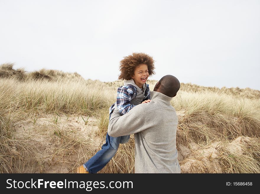 Father And Son Having Fun In Sand Dunes Having Fun