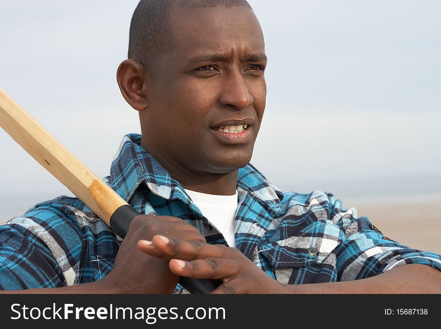 Young Man Playing Cricket On Beach Holiday