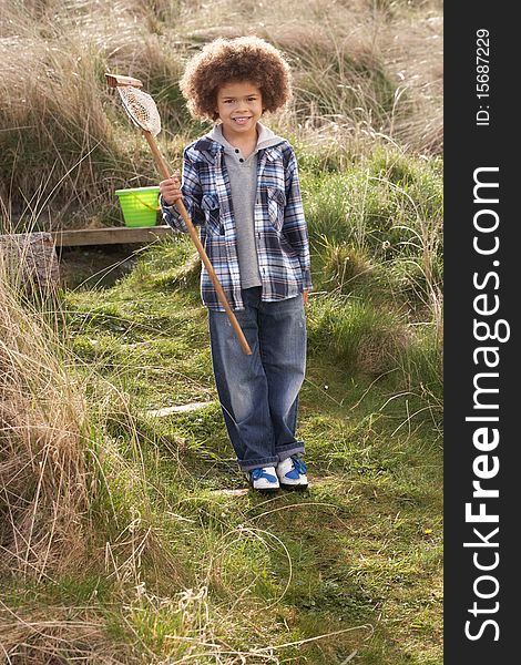 Young Boy Carrying Fishing Net At Seaside in the sun