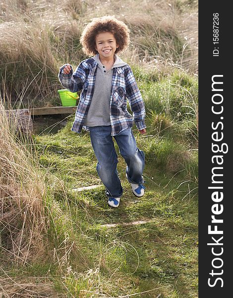 Young Boy Carrying Fishing Net At Seaside in the sun