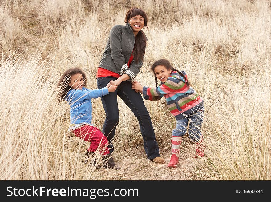 Mother And Daughters Having Fun In Sand Dunes in the sun