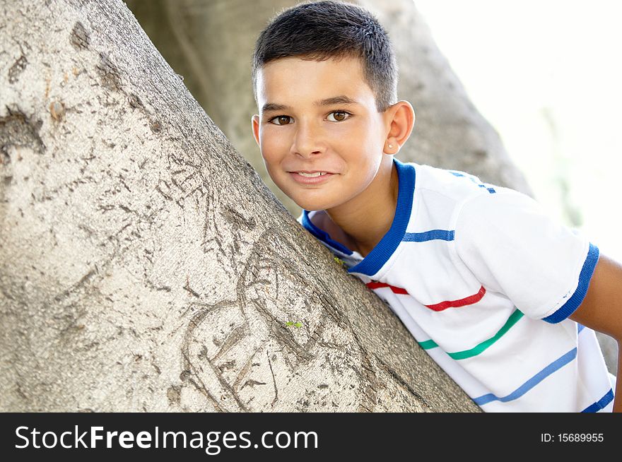 Portrait of a boy on the background of a tree trunk. Portrait of a boy on the background of a tree trunk.