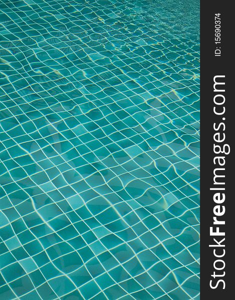 Background of rippled pattern of water in a green swimming pool