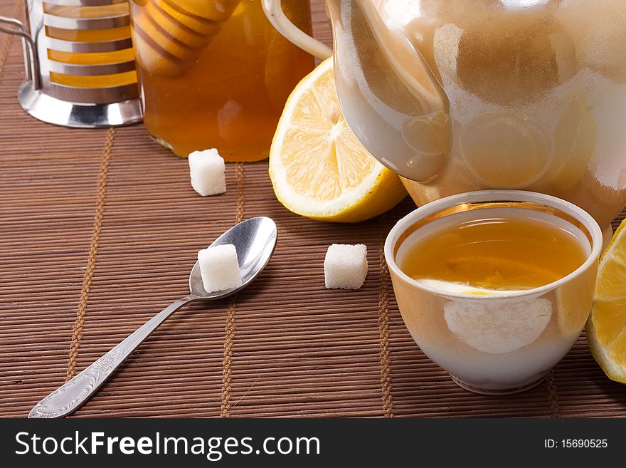 Tea, pot and honey on table