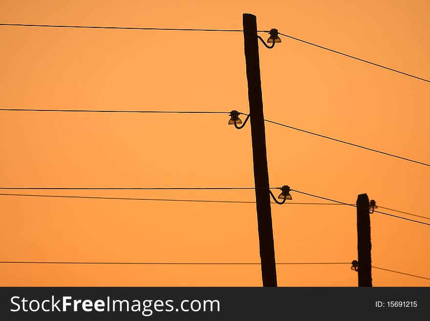 Old electrical poles at sunset