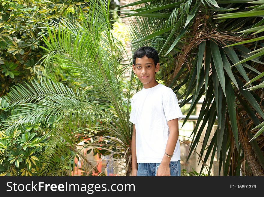 Portrait of a smiling boy in the background of tropical plants. Portrait of a smiling boy in the background of tropical plants.