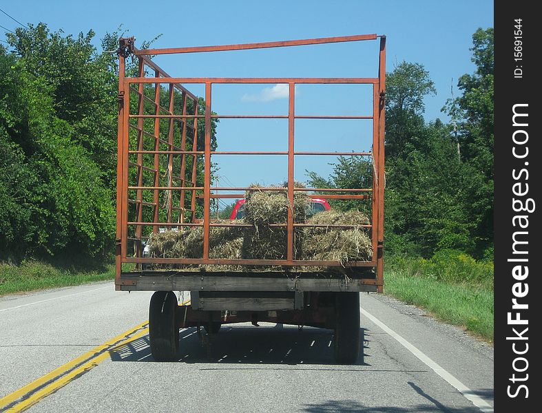 A hay wagon going down the highway