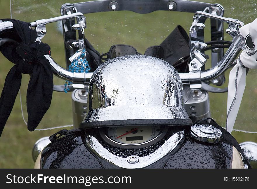 Detail of the front view of the motorbike with chrome helmet on the tank. Detail of the front view of the motorbike with chrome helmet on the tank.