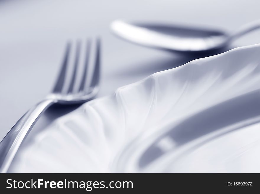 Empty curve plate, fork and spoon in blue at 10Mps