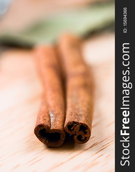 Two cinnamon sticks closeup on wooden background