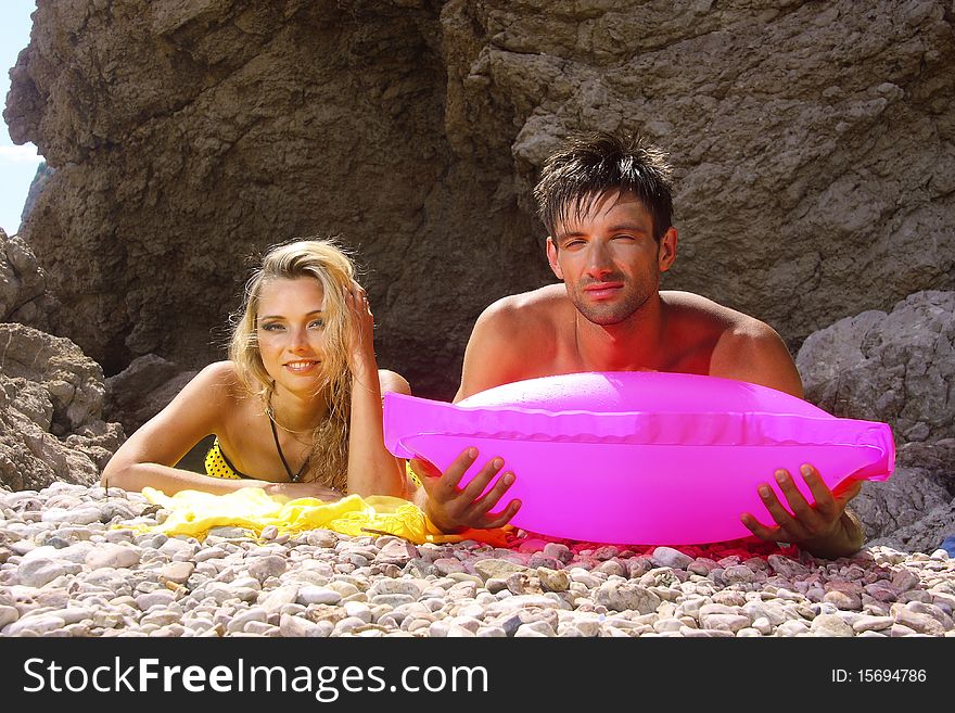 Married couple on a beach of pebbles near the rocks