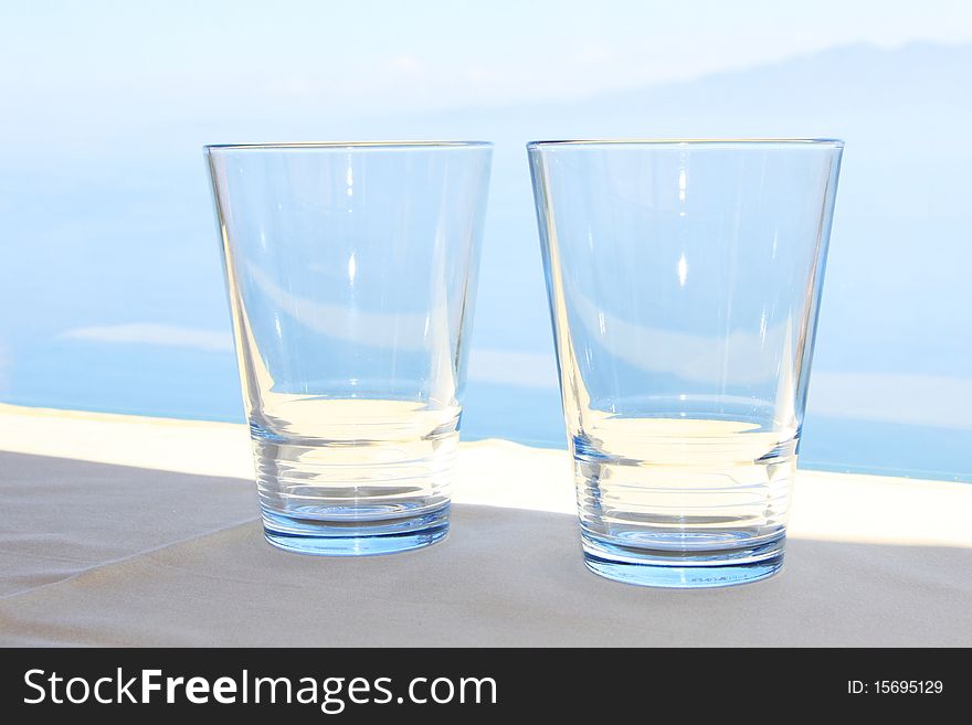Two blue water glasses in front de blue sea. Two blue water glasses in front de blue sea