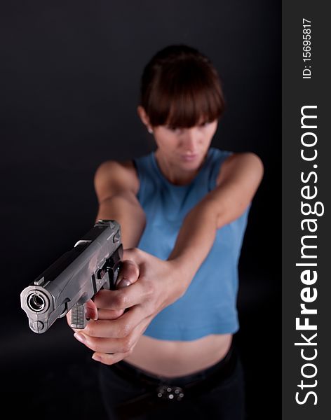 Woman with gun on black background