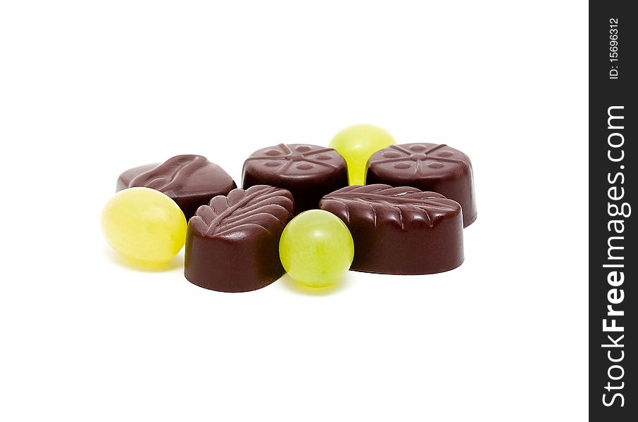 Chocolates with grapes on a white background. Chocolates with grapes on a white background
